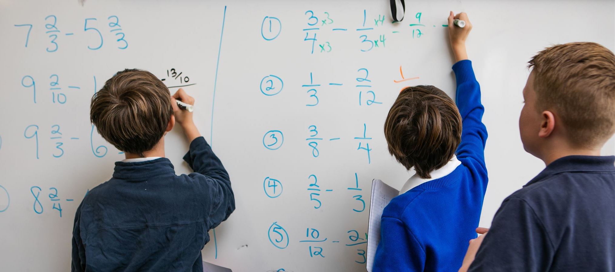 Student doing math on board